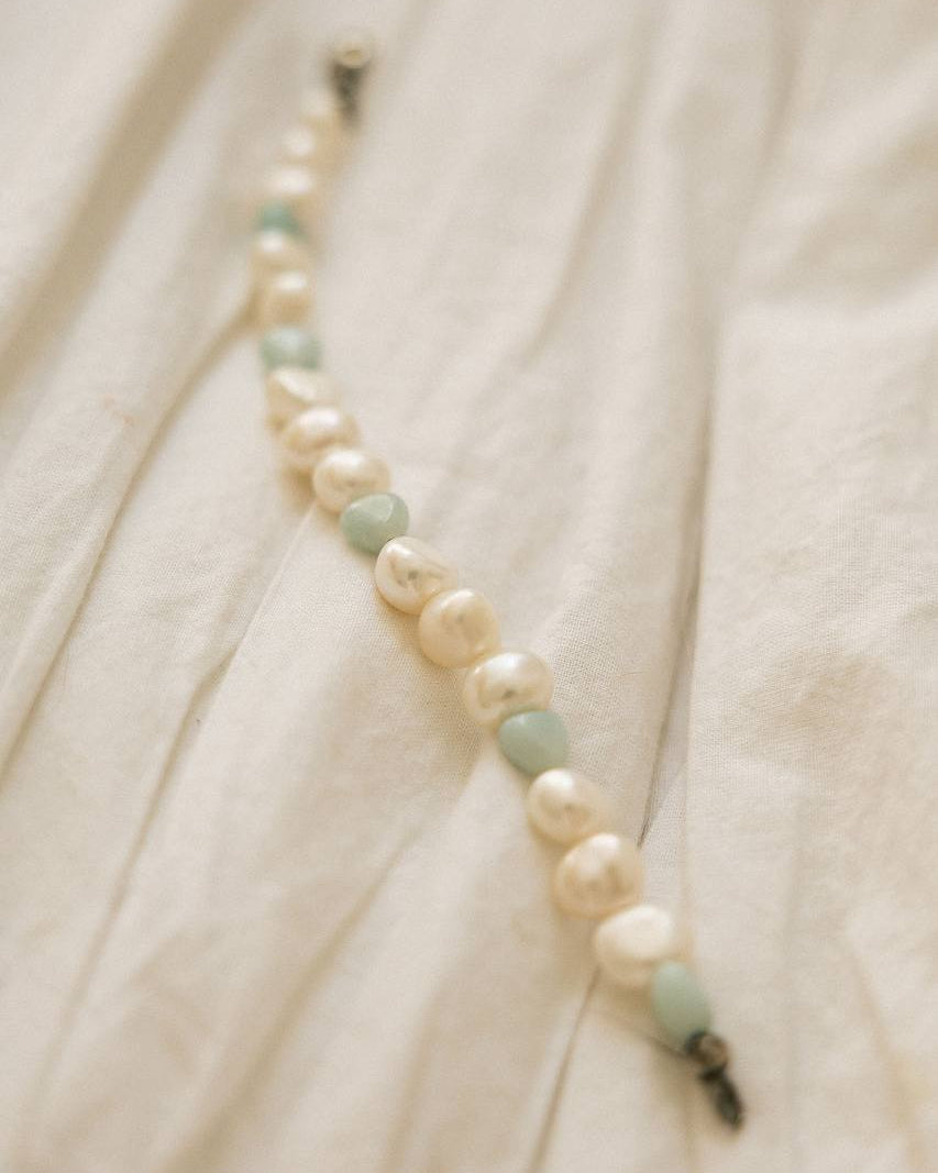Baroque Freshwater Pearl Bracelet flat lay on white linen showing pearls and blue stone beads