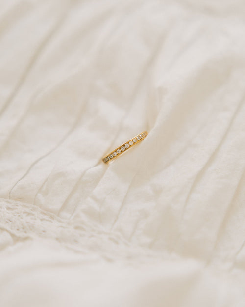 Crystal band ring gold-plated with rhinestones on white fabric