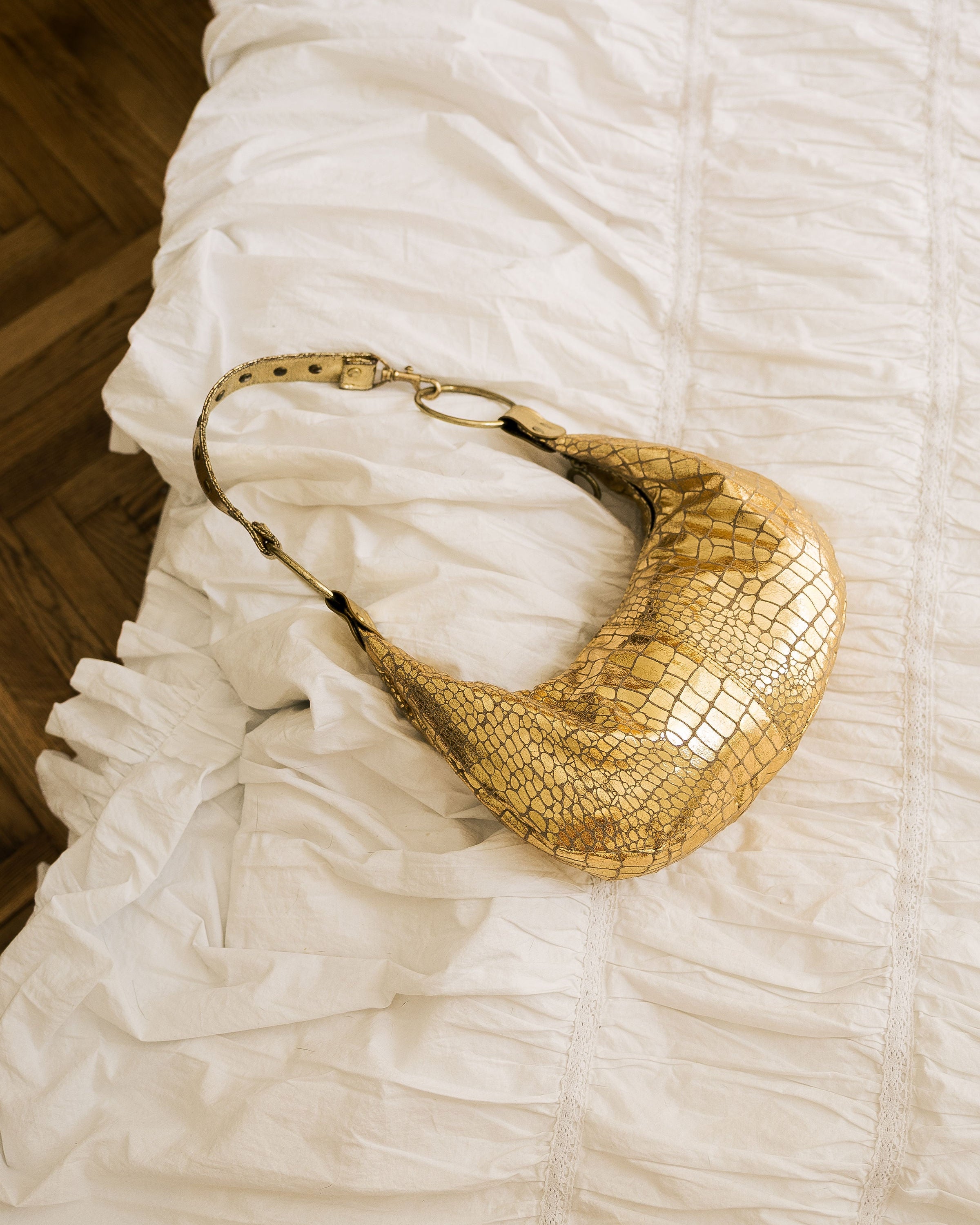 Gold Metallic Crescent Bag side view worn by model in grey shirt