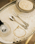 Gold Plated Chain Bracelet Anklet on silver tray with Diptyque candle and vintage cutlery