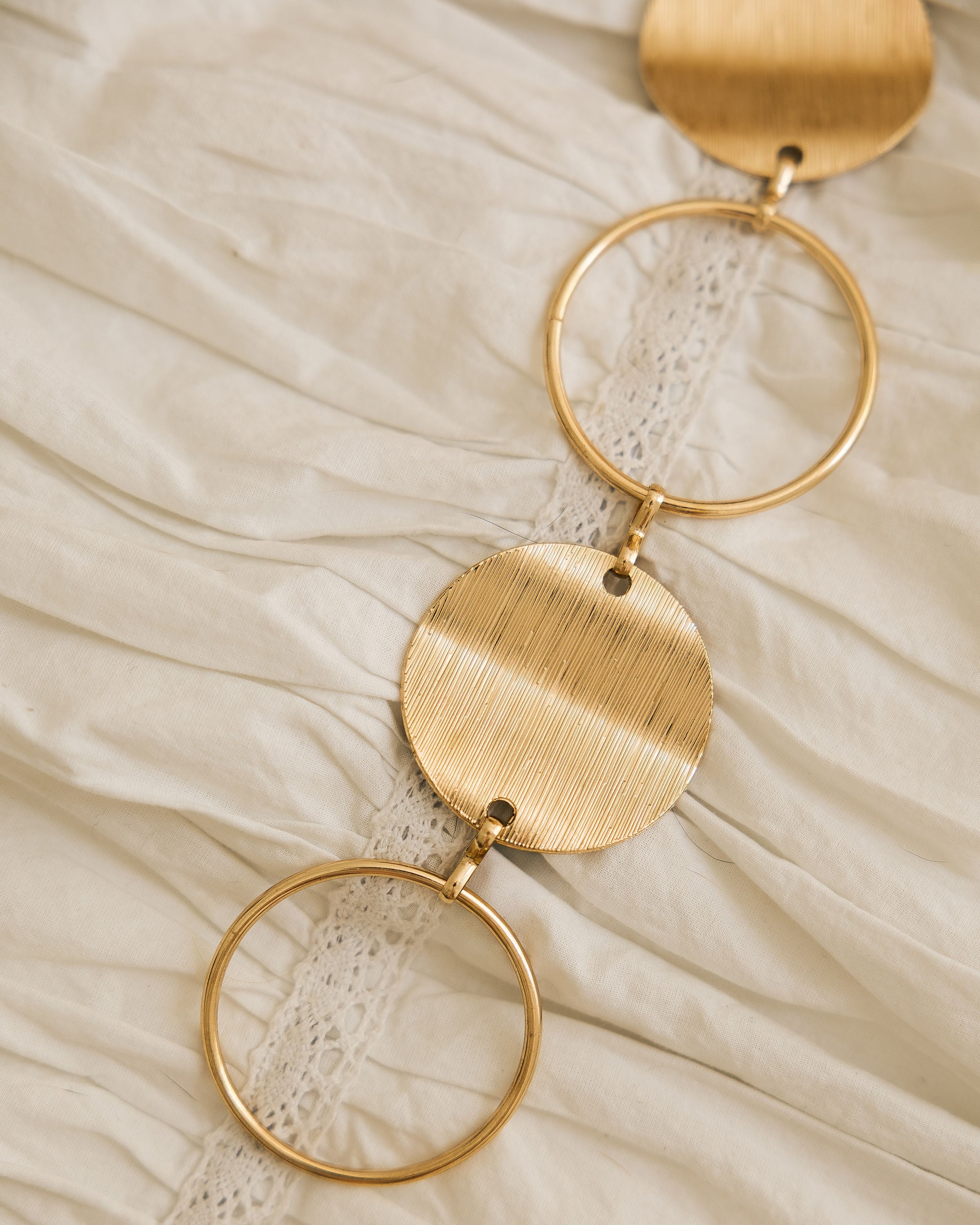 Gold Statement Disc Belt worn styled with grey shirt and gold crescent bag