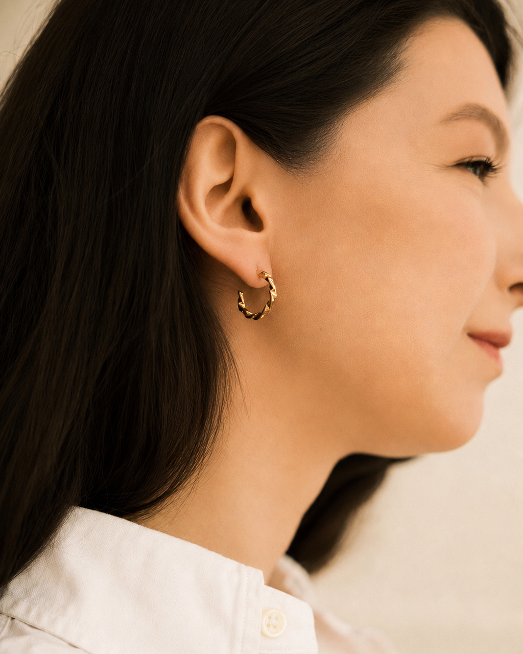 Twisted Gold Hoop Earrings worn by model in white shirt