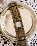 Vintage Watch with antique gold-tone finish and amber crystals on silver tray with lace cloth